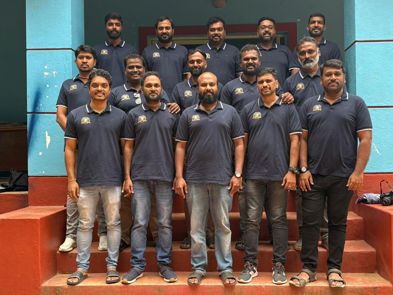 All 16 members of Prerana Trust in their navy uniforms — photographed at their adopted school in Bangalore